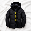 Black hooded puffer jacket displayed on a soft white cloth background, showcasing the insulated design, full front zip and practical winter styling.