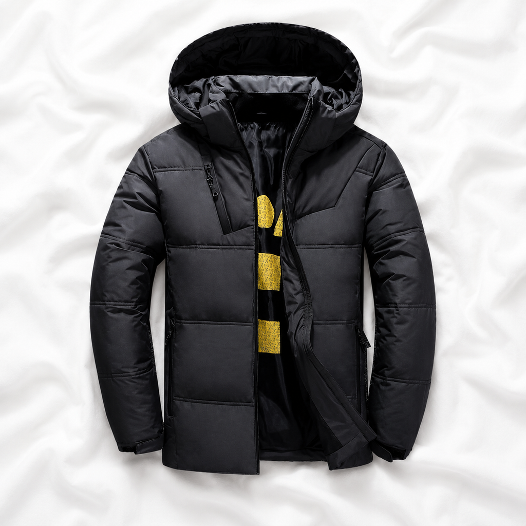 Charcoal hooded puffer jacket displayed on a soft white cloth background, highlighting its insulated design, quilted construction, full front zip and warm winter outerwear style.